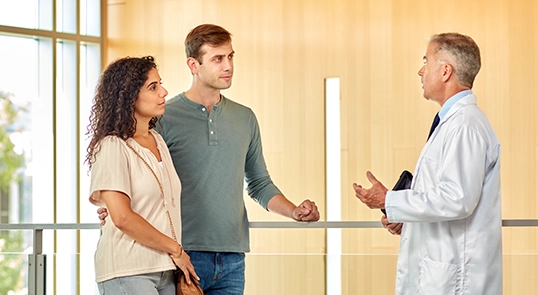 An acute lymphoblastic leukemia patient and their partner speak with a doctor.