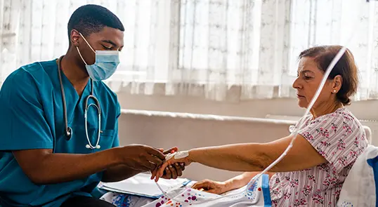 A nurse administers IV treatment to an acute lymphoblastic leukemia patient.