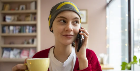 An acute lymphoblastic leukemia patient talks on their cellphone.